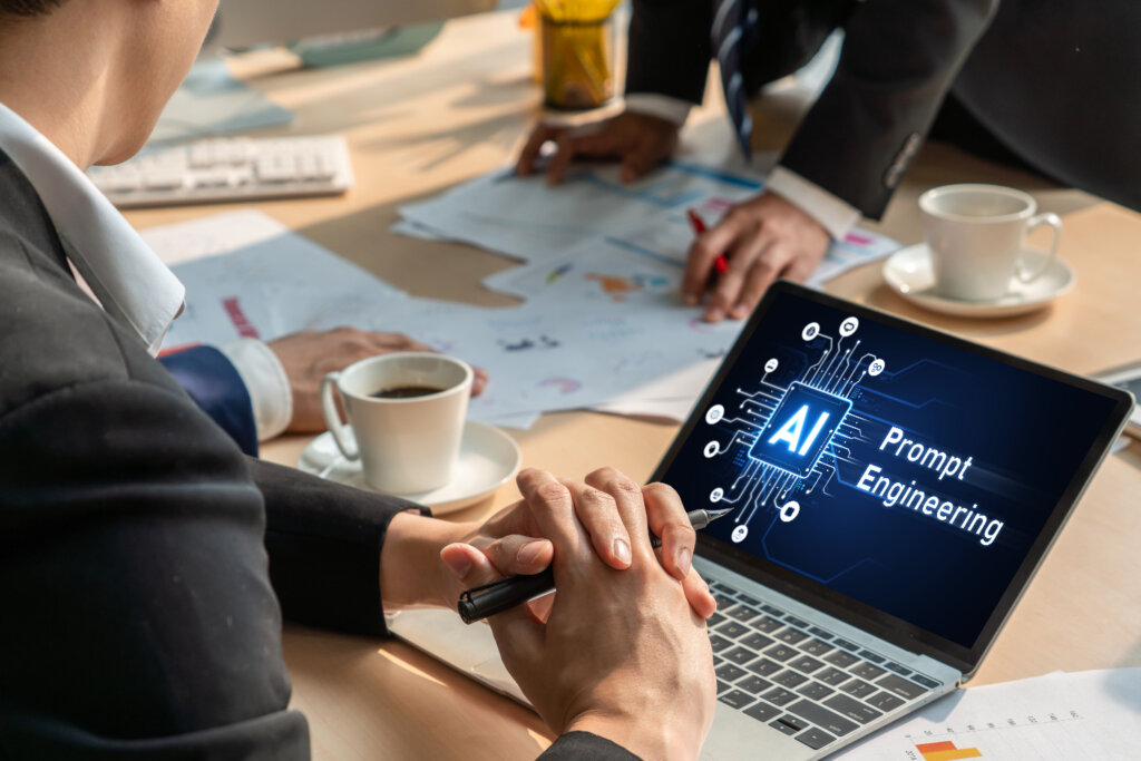 Business professionals discussing AI prompt engineering strategy using a laptop